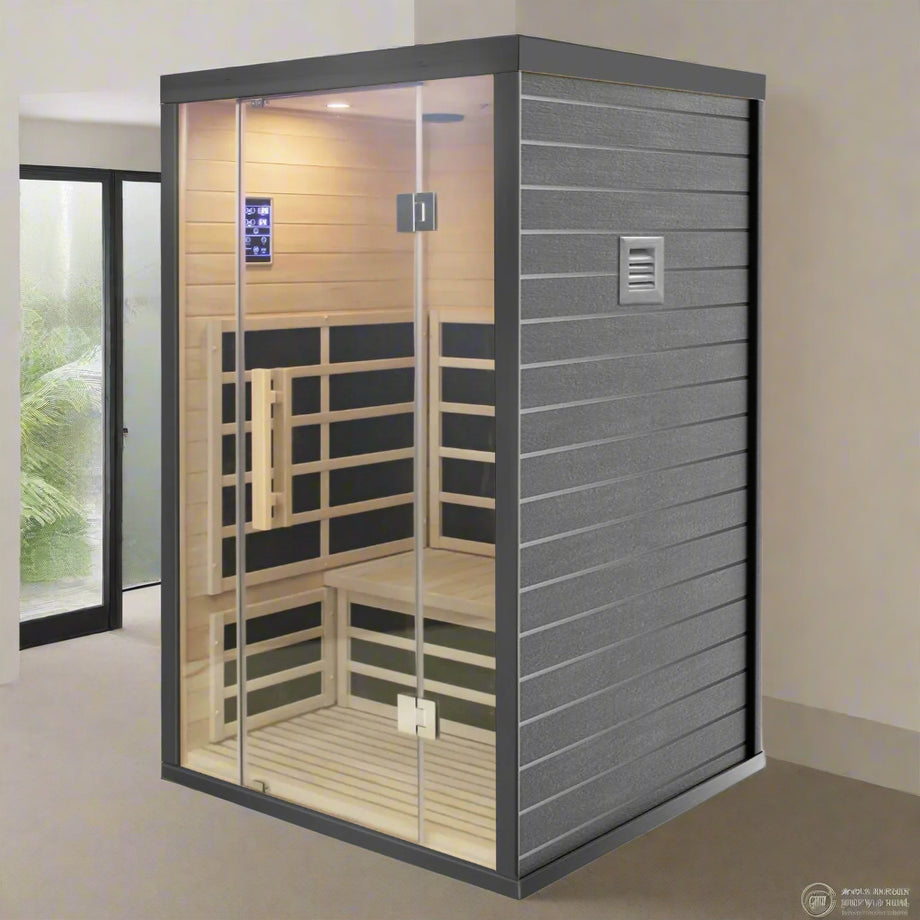 A two-person indoor infrared sauna with a sleek black finish and clear Hemlock wood interior. It includes wall and floor infrared panels, a glass door, and built-in speakers.