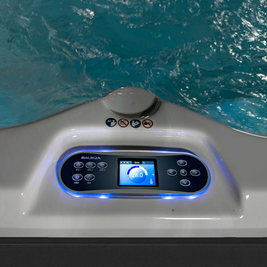 Swim spa mini pool control panel with digital display and buttons, set against the backdrop of a Swim spa mini pool filled with water.