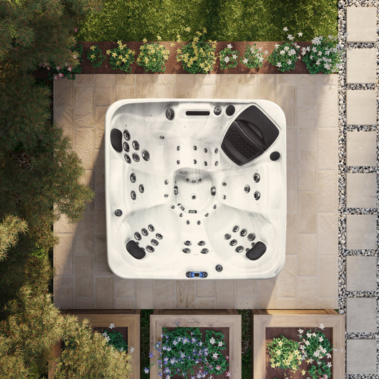 A top-down view of an outdoor hot tub installed in a garden setting, showcasing its design and seating arrangement.