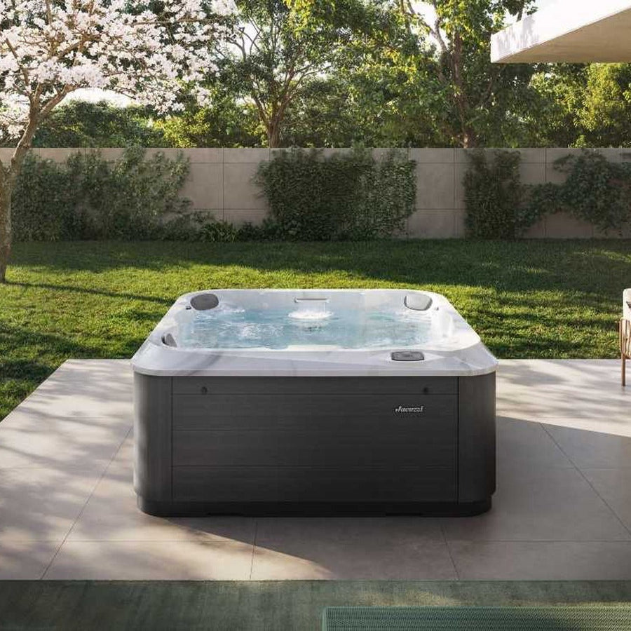Jacuzzi J-201 hot tub on a garden patio (brand lifestyle image)