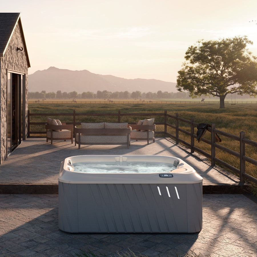 Jacuzzi J-225 hot tub in a garden setting (brand lifestyle image)