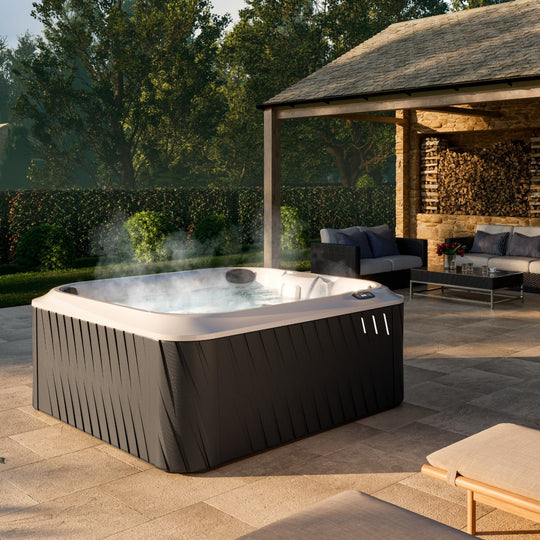 Jacuzzi J-245 hot tub in a garden setting (brand lifestyle image)