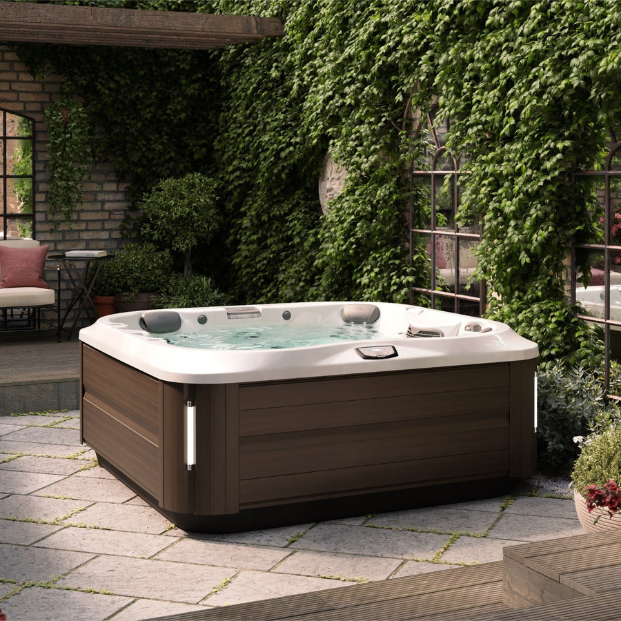 Jacuzzi J-335 hot tub on a garden terrace (brand lifestyle image)