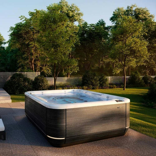 Jacuzzi J-509 hot tub in a landscaped garden (brand lifestyle image)