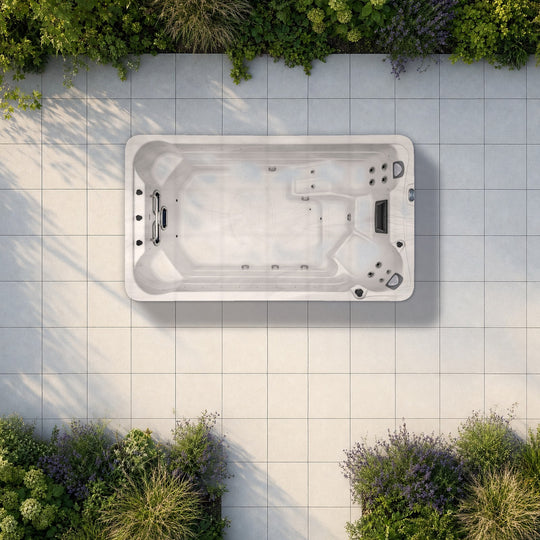 The Outdoor Living Active swim spa seen from above on a planted garden terrace, drawn to true scale on 60 cm paving slabs