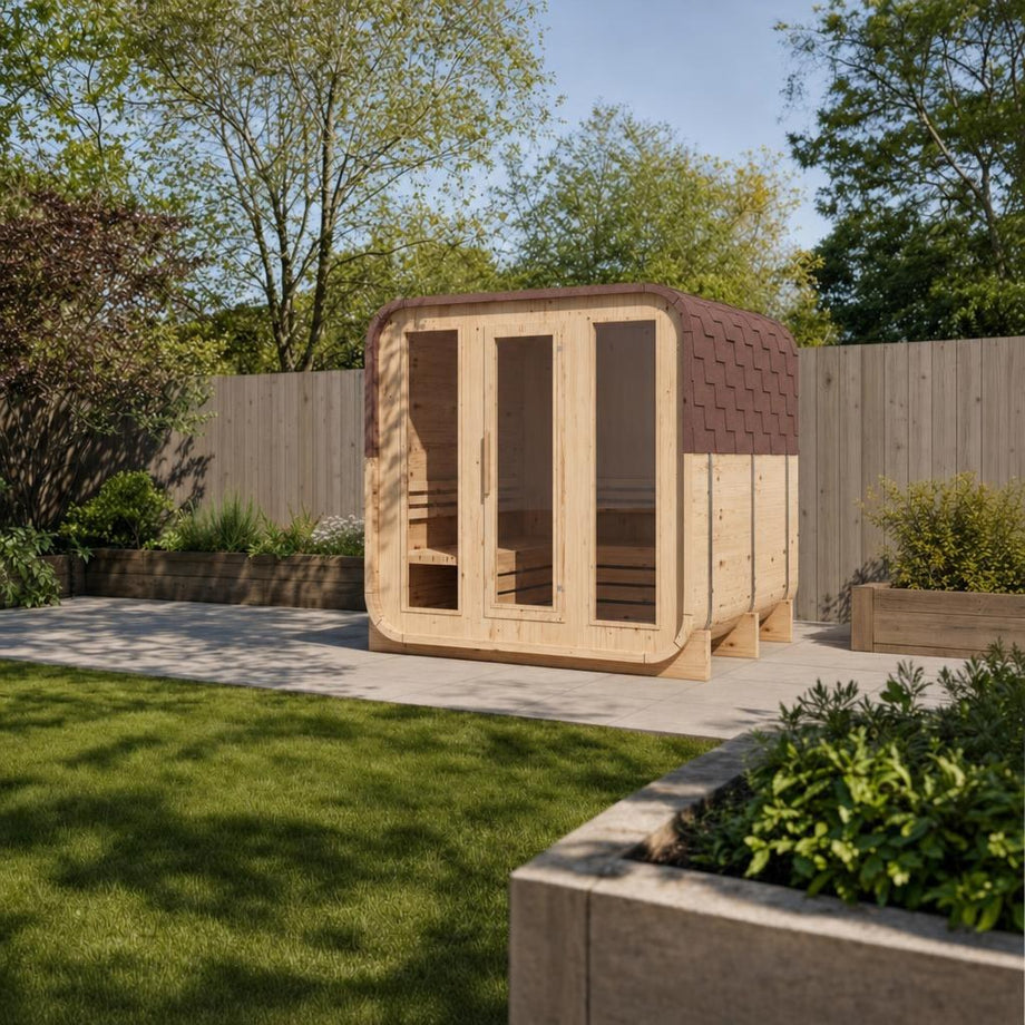 Illustrative lifestyle view of the Outdoor Living Cube sauna with its red-brown shingle roof in a UK garden