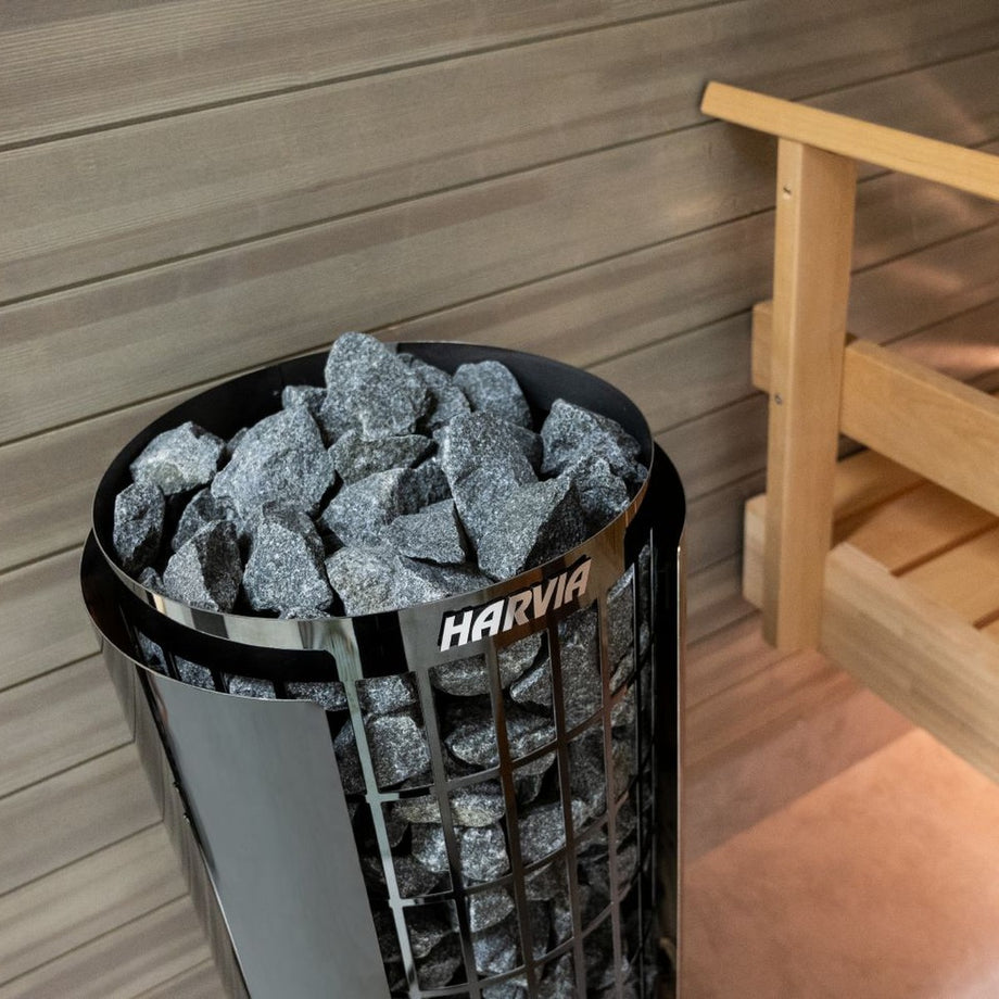 Black Harvia Cilindro heater next to a sauna bench