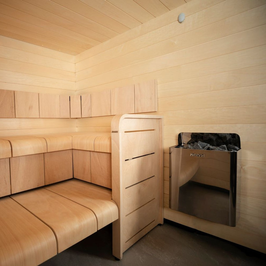 Compact sauna room with a Harvia The Wall heater beside the bench