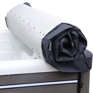 The rolled cover resting on the edge of a swim spa